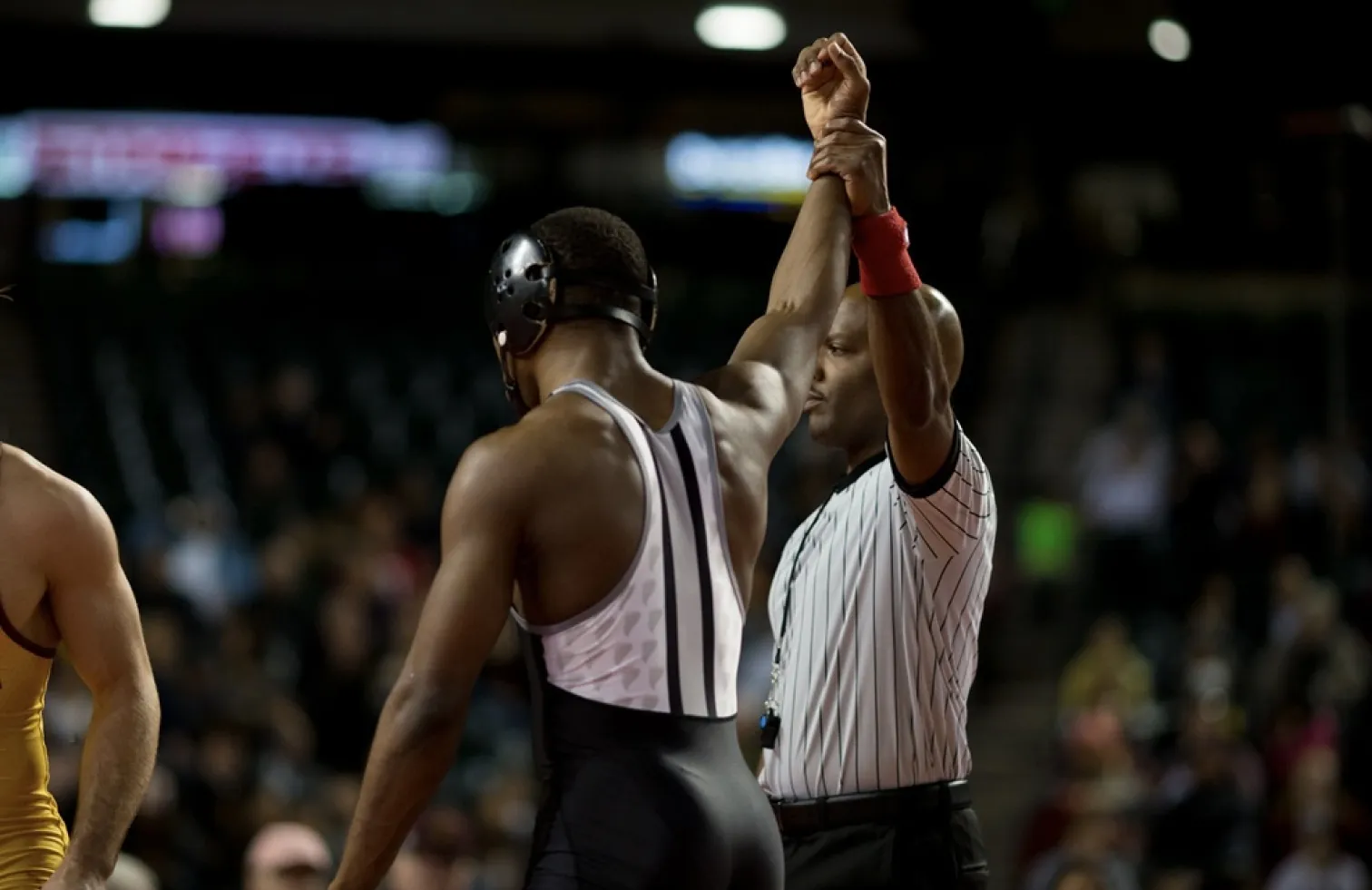 Coach raising arm of young wrestler in victory